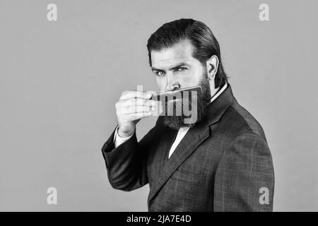 Maîtrisez le toilettage des cheveux et de la barbe dans la barbershop. Coiffeur fait la coiffure.Portrait de mode de l'hipster. Beau homme avec une longue barbe à cheveux foncés Banque D'Images