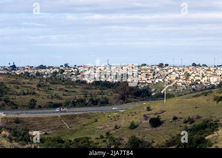 Thembelethu village résidentiel à faible revenu à George, Western Cape, Afrique du Sud montrant des voitures roulant sur l'autoroute N2 et des arbres verts et des légumes Banque D'Images