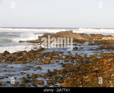 L'eau de mer se lavant contre les rochers dans la région côtière de Mossel Bay sur la route des jardins de l'Afrique du Sud Banque D'Images