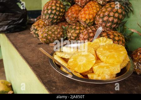 Ananas frais récoltés en vente près de la route principale à Madagascar, fruits d'orange juteux prêts à manger Banque D'Images