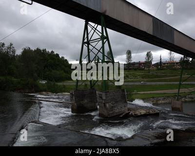 Au sommet de la chute d'eau, Revelfossen, nous voyons le tapis convoyeur intégré qui circule environ 3 km dans l'air entre les usines d'iron et l'usine de cokage Banque D'Images