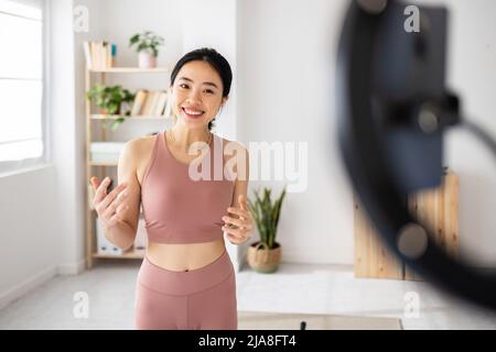 Fitness asiatique jeune femme enregistrement de cours en ligne à la maison Banque D'Images