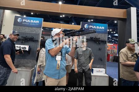 Houston, États-Unis. 28th mai 2022. Les amateurs d'armes à feu magasinent pour des armes à feu, des munitions et des produits de plein air au stand Pulsar de Mansfield, Texas, le samedi matin, au salon professionnel de la National Rifle Association (NRA), le 28 mai 2022 à Houston. Les expositions couvrent près de 14 hectares à l'intérieur du centre de congrès George R. Brown. Crédit : Bob Daemmrich/Alay Live News Banque D'Images