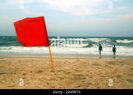 Deux personnes se sont prélasser dans les vagues de l'océan, malgré l'avertissement du drapeau rouge à Robert Moses Beach sur long Island Banque D'Images