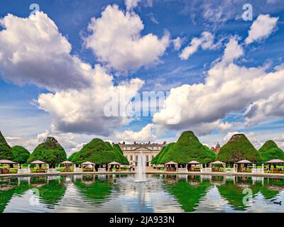 9 juin 2019: Richmond, Royaume-Uni - Hampton court Palace et l'East Garden, avec topiaire reflétée dans le lac et une petite fontaine, les visiteurs marchant autour Banque D'Images