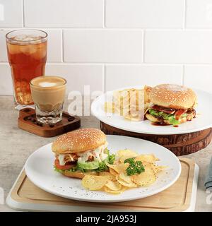 Mini-hamburger avec chips de pommes de terre, café au lait et thé glacé. Concept de menu Cafe avec espace de copie pour le texte Banque D'Images