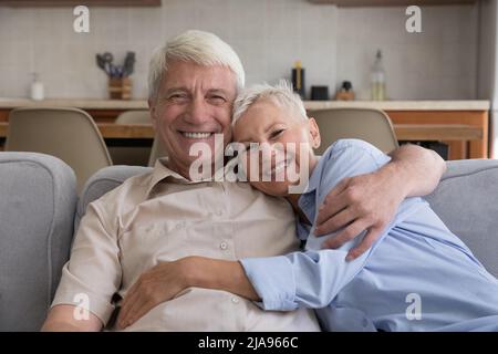 Portrait de famille en tête souriant mari senior femme se câliner sur le canapé Banque D'Images