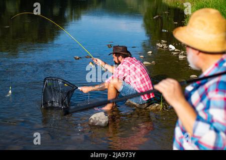 Pêcheurs hommes amis et truite trophée. Père et fils de pêche. Générations hommes pêche dans la rivière. Banque D'Images