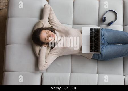 Sans souci paisible, jolie 20s filles se détendant sur un canapé confortable et doux Banque D'Images