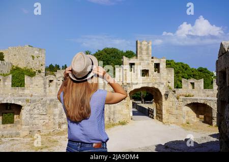 Vacances à Rhodes, Grèce. Vue arrière de la jeune fille de voyageur appréciant la vue de la porte de Saint Paul dans la ville de Rhodes fortifications, Grèce. Jeune femme tou Banque D'Images