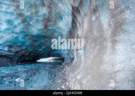 Grotte bleue sculptée dans la glace du glacier de Vallelunga traversée par un ruisseau, en Italie Banque D'Images