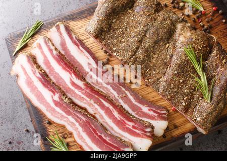 Pancetta de porc strippy et saumue fumée sur la bande de bois sur le panneau de bois sur la table. Vue horizontale du dessus Banque D'Images