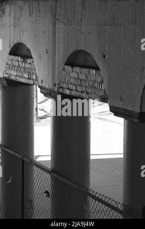 Colonnade industrielle du centre-ville de colonnes en béton tenant un pont en noir et blanc. Banque D'Images