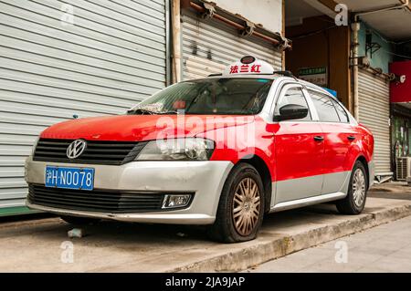 Un taxi abandonné collectant de la poussière et avec un pneu à plat devant une rangée de magasins avec volets dans le district de Putuo, Shanghai, Chine pendant la fin de Shang Banque D'Images
