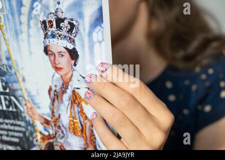 Éventail avec les ongles peints avec le drapeau britannique tenant une copie du magazine OK avec une photo de la Reine's Coronation. Jubilé de platine juin 2022 Banque D'Images