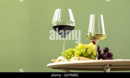 Verres de vin blanc et rouge avec raisins Banque D'Images