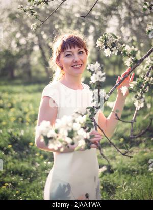 Portrait de jeune femme sur fond de pommiers en fleurs Banque D'Images