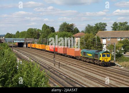 Une locomotive diesel Freightliner de classe 66 numéro 66592 se dirige vers le sud le long de la ligne principale de la côte ouest, à South Kenton, avec un train à conteneurs. Banque D'Images