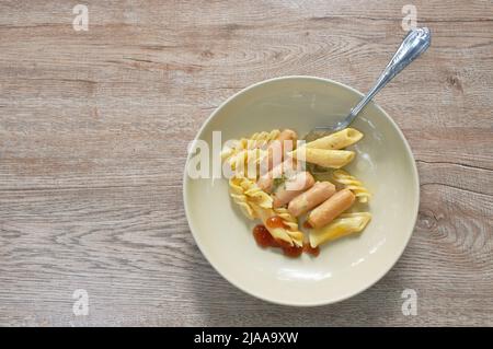 faites cuire le fusilli et le penne avec des saucisses de porc en sauce aux algues sur l'assiette Banque D'Images