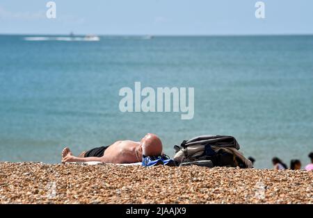 Brighton UK 29th mai 2022 - les visiteurs profitent du soleil sur le front de mer et la plage de Brighton car le temps frais est prévu pour le Royaume-Uni au cours des prochains jours : Credit Simon Dack / Alay Live News Banque D'Images