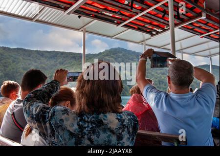 Parc national des lacs de Plitvice CROATIE - 3 septembre 2018: Les touristes prennent des photos de cascades d'un bateau flottant sur le lac Banque D'Images