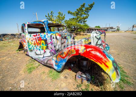 Voiture peinte abandonnée au ranch VW Slug bug, Panhandle, TX, États-Unis. Une attraction sur la route 66. Vieille voiture peinte dans des couleurs vives Banque D'Images