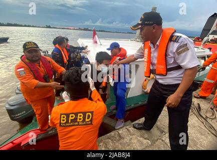 Banjarmasin. 29th mai 2022. La photo du téléphone portable prise le 29 mai 2022 montre des sauveteurs tirant un survivant au port de Trisakti à Banjarmasin, Kalimantan du Sud, Indonésie. Les sauveteurs ont déployé un hélicoptère et plusieurs navires avec plus de 100 personnes dans une opération de recherche et sauvetage pour 25 personnes disparues après qu'un navire a coulé dans l'eau au large de la province de Sulawesi Sud en Indonésie, a déclaré un secouriste dimanche. Credit: Bahaudin Quusairi/Xinhua/Alay Live News Banque D'Images