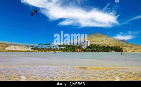 Un seul kite surfeur sur une plage de sable longue et infinie dans les eaux peu profondes de ruisseau ebb, station balnéaire, collines sèches, ciel bleu - Playa de Sotavento, Fuertev Banque D'Images