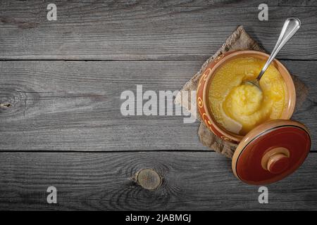 Pur OU Desi ghee également connu sous le nom de beurre liquide clarifié. Pure OU Desi ghee dans des bols en céramique sur une ancienne table en bois. Vue de dessus. Banque D'Images