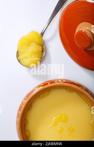 Pur OU Desi ghee également connu sous le nom de beurre liquide clarifié. Pur OU Desi ghee dans des bols en céramique sur une table blanche. Vue de dessus. Banque D'Images