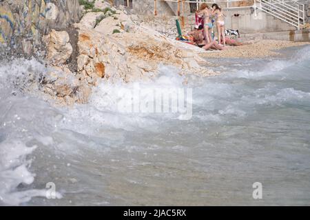 Les vagues éclaboulent sur le rocher. Mer de tempête sur la plage de Pecine à Rijeka, Croatie. L'été sur une plage de Pecine près de la ville de Rijeka. Banque D'Images