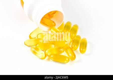 Pilules ovales jaunes brillantes avec de l'huile de poisson (vitamine oméga-3) dans la bouteille médicale sur fond blanc. Banque D'Images
