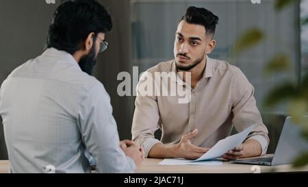 Hispanique jeune homme d'affaires homme conseiller financier agent avocat travailleur consultant inconnu client masculin expliquant les avantages du contrat d'assurance Banque D'Images