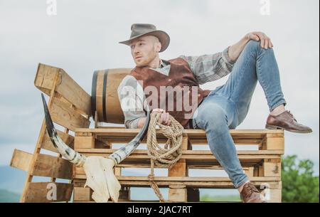 Cowboy portant un chapeau.La vie occidentale.Beau fermier de l'Ouest barbu.Portrait d'homme cow-boy ou fermier.Ouest.Mode rétro pour hommes, mode vintage, brutal Banque D'Images