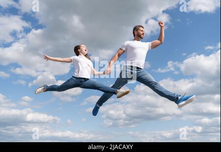 une famille heureuse de père et de fille sautent dans le ciel Banque D'Images