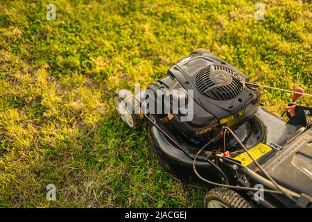 Déplacement de pelouse sur l'herbe verte dans le jardin moderne. Banque D'Images