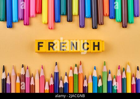 Cadre à partir de crayons colorés et mot FRANÇAIS écrit sur des cubes en plastique. Concept de langue étrangère. Banque D'Images