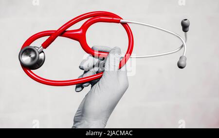 main du médecin en gants bleus tenant un stéthoscope. médecine et santé. diagnostic Banque D'Images