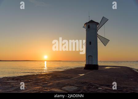 Stawa Mlyny, un phare en forme de moulin à vent, symbole officiel de Swinoujscie au coucher du soleil Banque D'Images