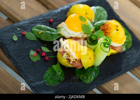 Gros plan des mini burgers des œufs de caille avec des pommes de terre cuites à l'assiette avec des légumes verts Banque D'Images