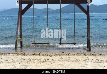 Balançoires en bois sur la plage de sable vietnamien Banque D'Images