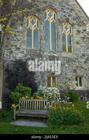 Vider le banc en bois et les fleurs printanières dans le jardin de l'église Ryerson United Church à Kerrisdale, Vancouver, C.-B., Canada Banque D'Images