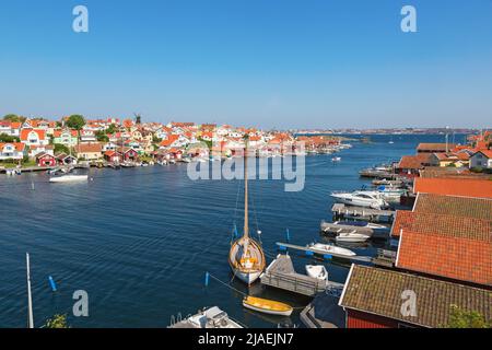 Vue sur Fiskebackskil un vieux village côtier sur la côte ouest suédoise, avec la ville de Lysekil en arrière-plan en été Banque D'Images