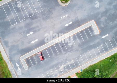 Vue aérienne de haut en bas de la voiture rouge SUV garée sur le parking en béton avec ligne blanche de signalisation routière sur la rue. Vue au-dessus de la voiture de suite chez pa Banque D'Images