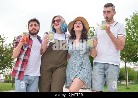 Groupe d'amis heureux de boire des boissons rafraîchissantes et rire. Banque D'Images