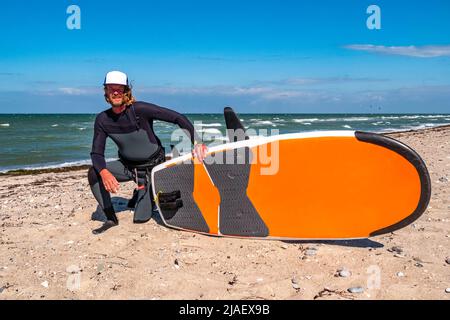 Portrait d'un homme kite foil surfeur avec une planche posant sur la plage Banque D'Images