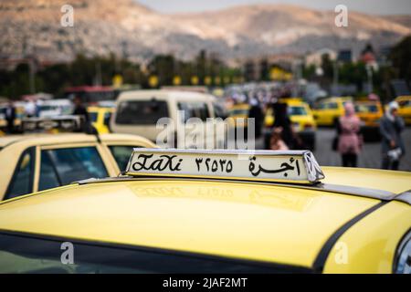 Damas, Syrie - Mai, 2022: Panneau taxi près sur voiture taxi dans la circulation de rue de Damas Banque D'Images