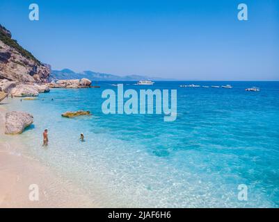 Golfo di Orosei Sardina, hommes et femmes sur la plage Sardaigne Italie, jeune couple vacances Sardaigne Italie, couple hommes et femme jouant dans l'océan avec l'eau bleu clair en Italie Banque D'Images