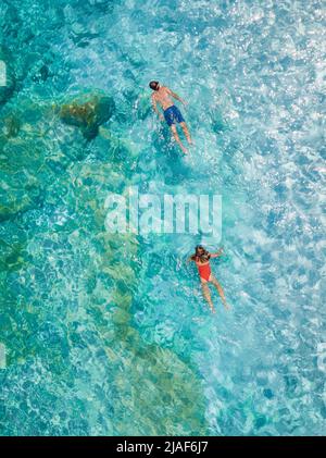 Golfo di Orosei Sardina, hommes et femmes sur la plage Sardaigne Italie, jeune couple vacances Sardaigne Italie, couple hommes et femme jouant dans l'océan avec l'eau bleu clair en Italie Banque D'Images