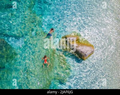 Golfo di Orosei Sardina, hommes et femmes sur la plage Sardaigne Italie, jeune couple vacances Sardaigne Italie, couple hommes et femme jouant dans l'océan avec l'eau bleu clair en Italie Banque D'Images